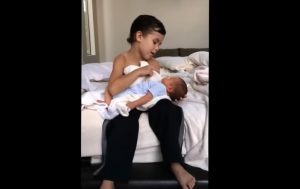 Heartwarming scene, six-year-old big brother, newborn baby brother, sibling love, serenade, bonding through music, touching moment, unbreakable sibling bond, innocence and tenderness, expressions of affection