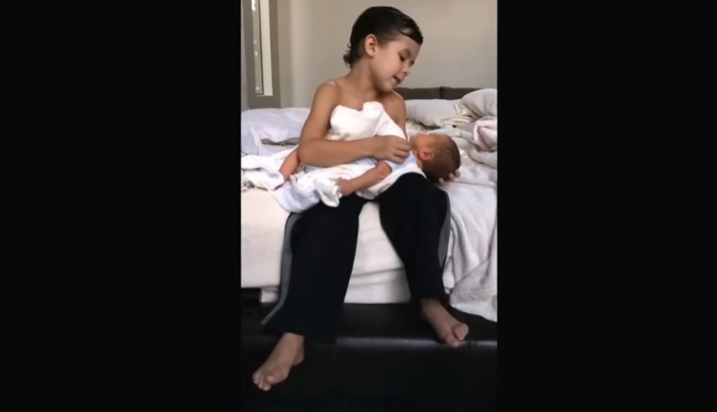 Heartwarming scene, six-year-old big brother, newborn baby brother, sibling love, serenade, bonding through music, touching moment, unbreakable sibling bond, innocence and tenderness, expressions of affection