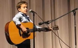 Guitar Prodigy, Little Johnny Cash, Folsom Prison Rendition, Guitar Performance, Second Grader Talent, School Concert, Talented Kids, Future of Music, Budding Star, Unique Guitar Talent.