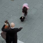 A kid tips a street Musician