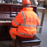 A traffic Marshall sits down at a public piano