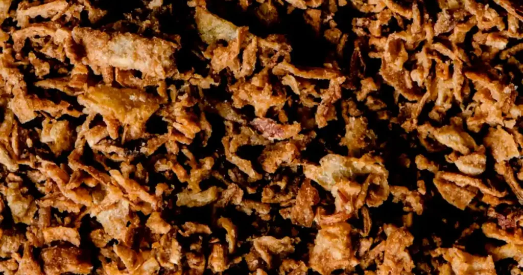Appetizing close-up of crispy golden fried onions perfect for culinary uses..