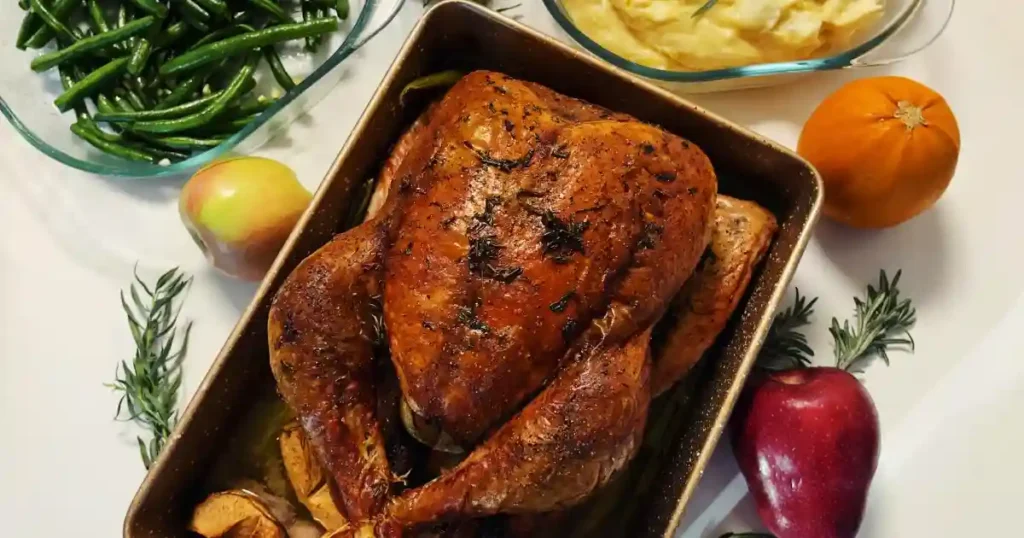 Delicious Thanksgiving meal featuring a perfect roast turkey, sides of mashed potatoes and green beans..
