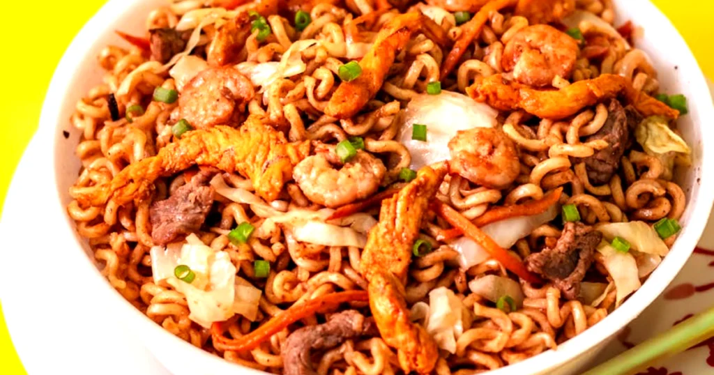 Delicious stir-fried noodles with chicken, shrimp, and vegetables in a bowl..