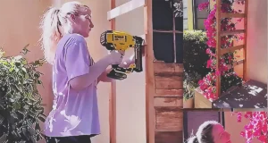 A small front garden corner transformed with a handmade wooden trellis supporting a climbing bougainvillea plant, creating a bright and welcoming floral entrance.