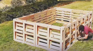 A DIY backyard pool project made from old wooden pallets, showing an upcycled outdoor build that transforms discarded materials into a creative summer pool idea.