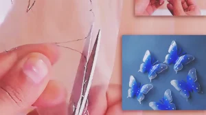 Blue and transparent butterflies made from recycled plastic bottles, decorated with pearl beads and displayed on a wall near a window as handmade DIY wall decor.