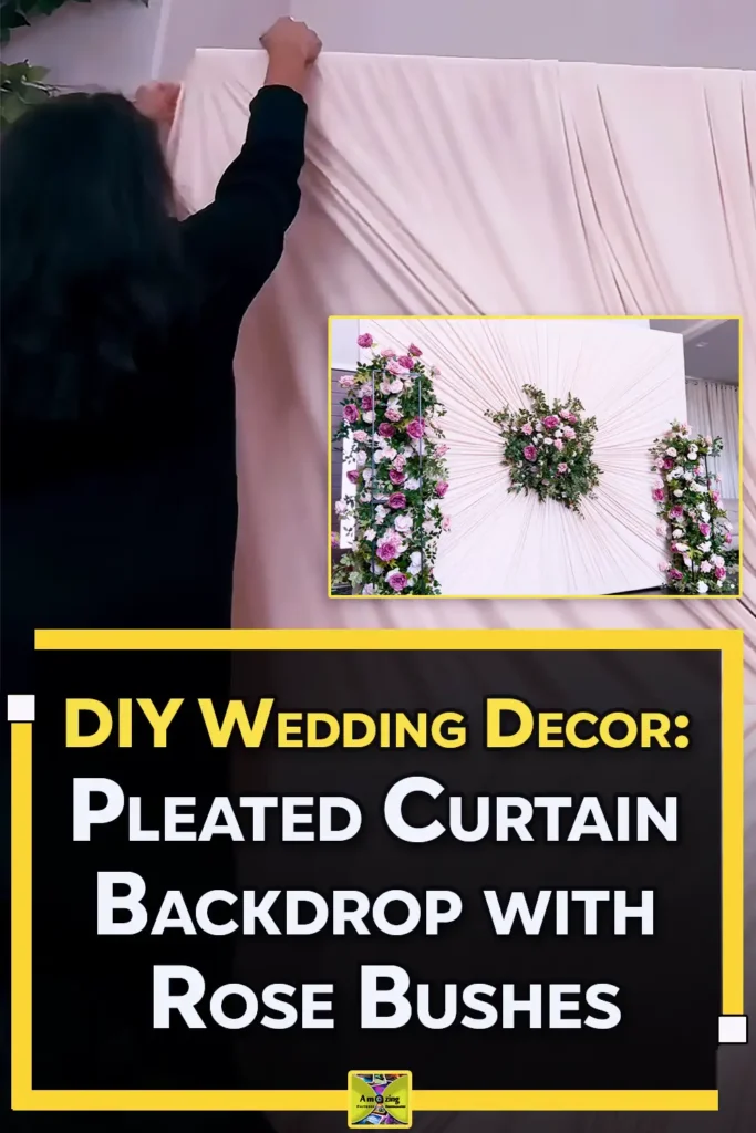 An elegant DIY wedding backdrop made from ivory curtains gathered into a pleated sunburst design with pink rose floral arrangements in the center and on both sides.
