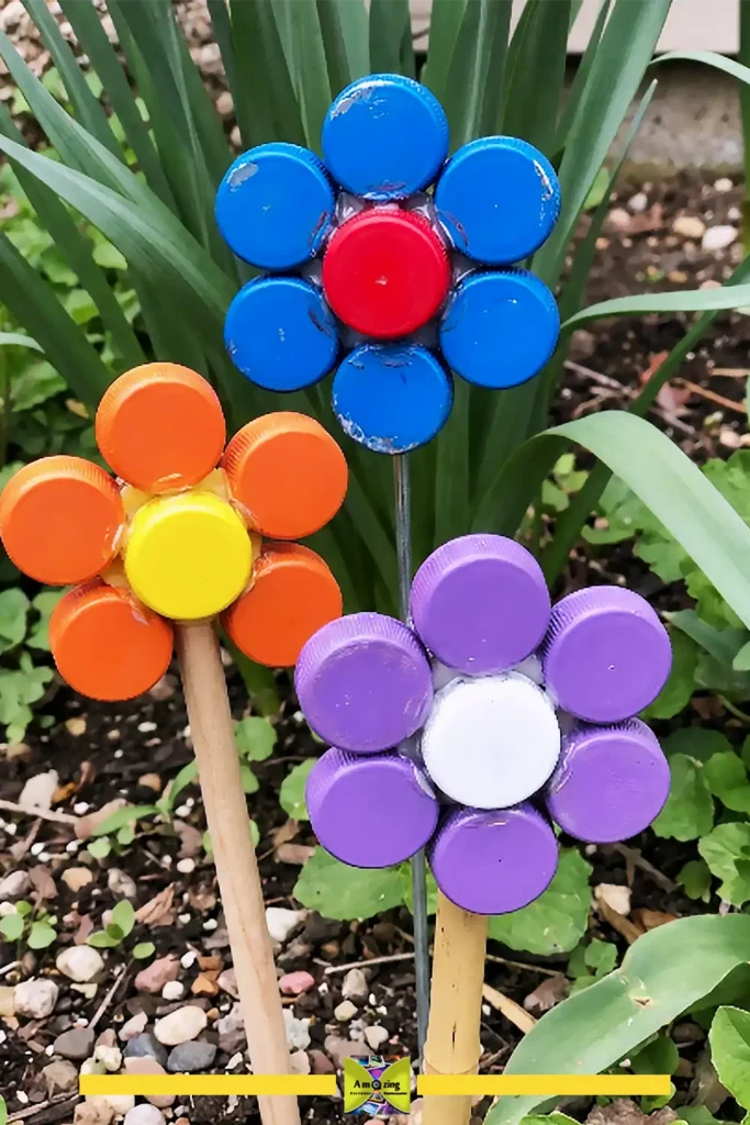Garden art flowers made from plastic bottle caps on stakes in a colorful pot
