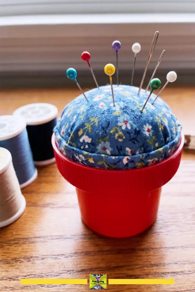 Mini pincushion made from a plastic bottle cap filled with fabric and pins