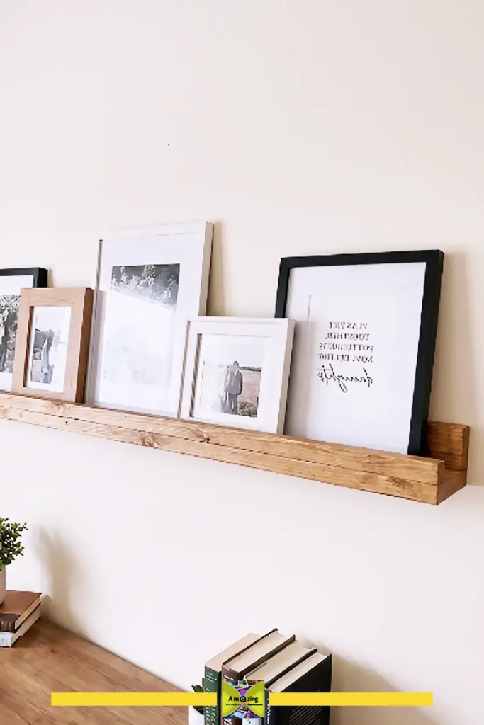 Pallet picture ledge displaying framed photos and art against a wall