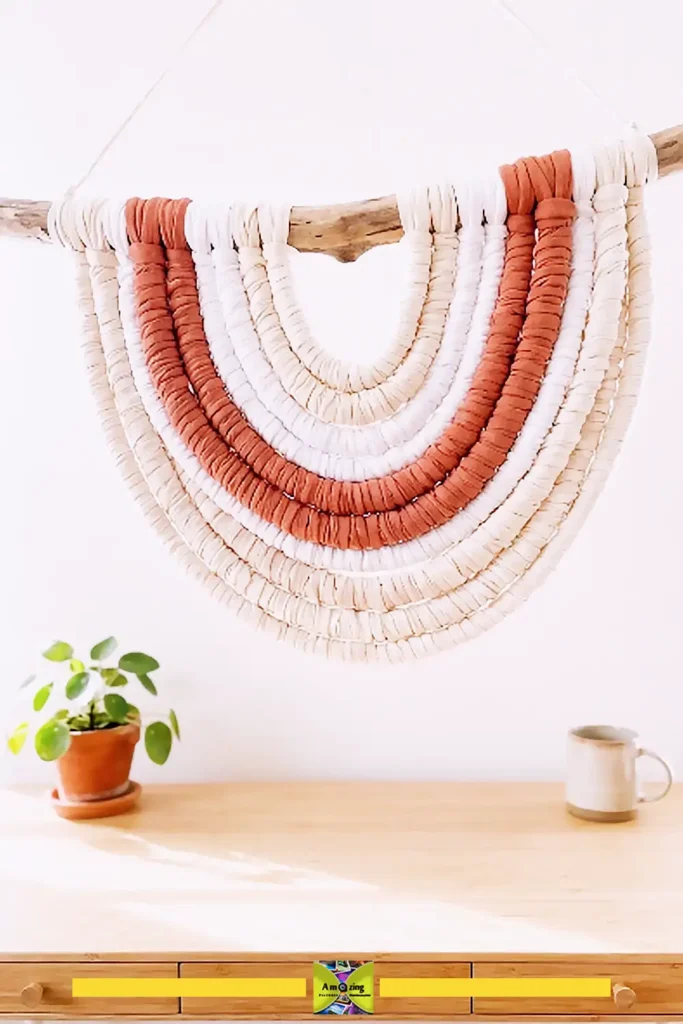 Old T-shirt boho wall hanging in cream made from knotted fabric strips on a branch