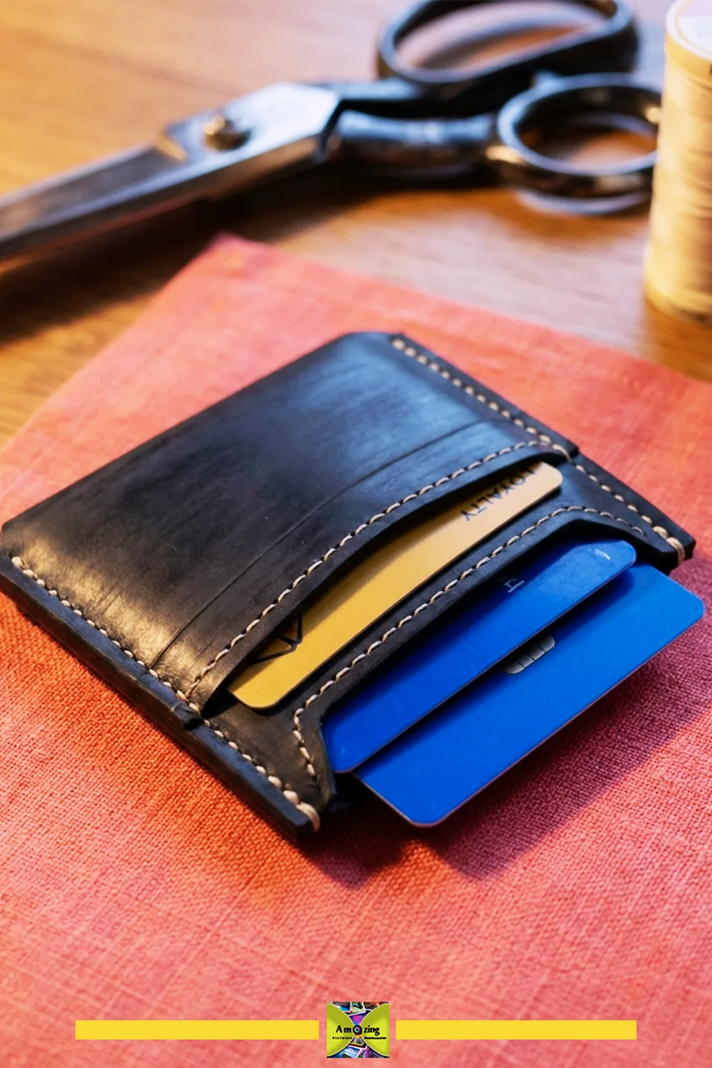 Hand-stitched black rubber card sleeve showing the reinforced top opening and visible seam allowance