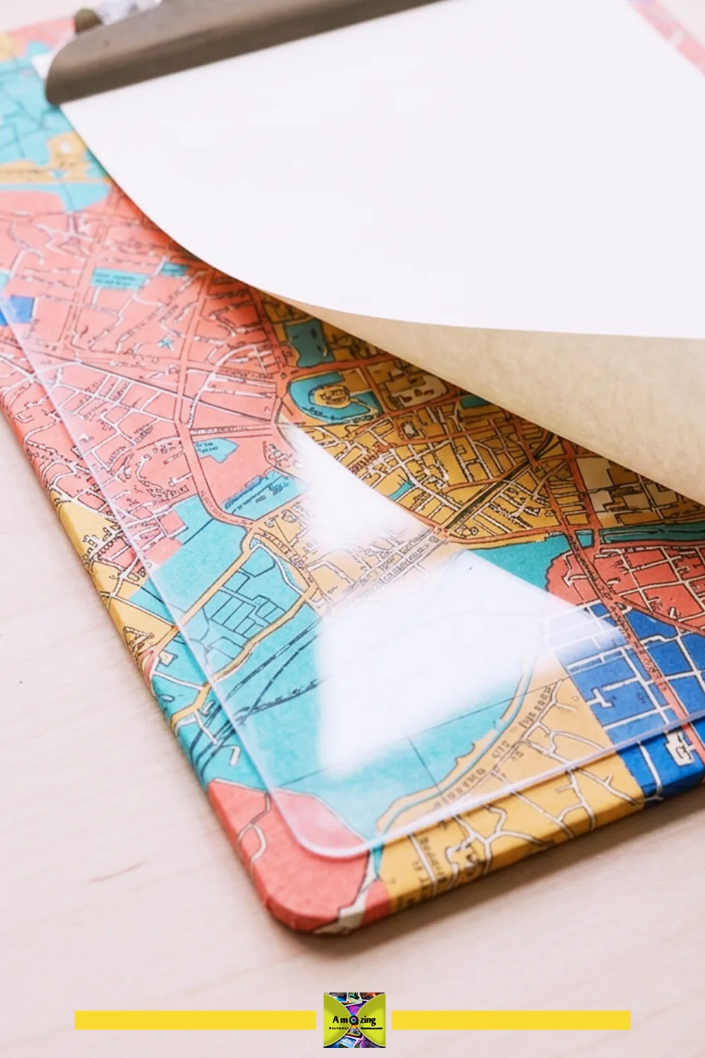 Map-covered clipboard with a transparent cover and blank writing paper.