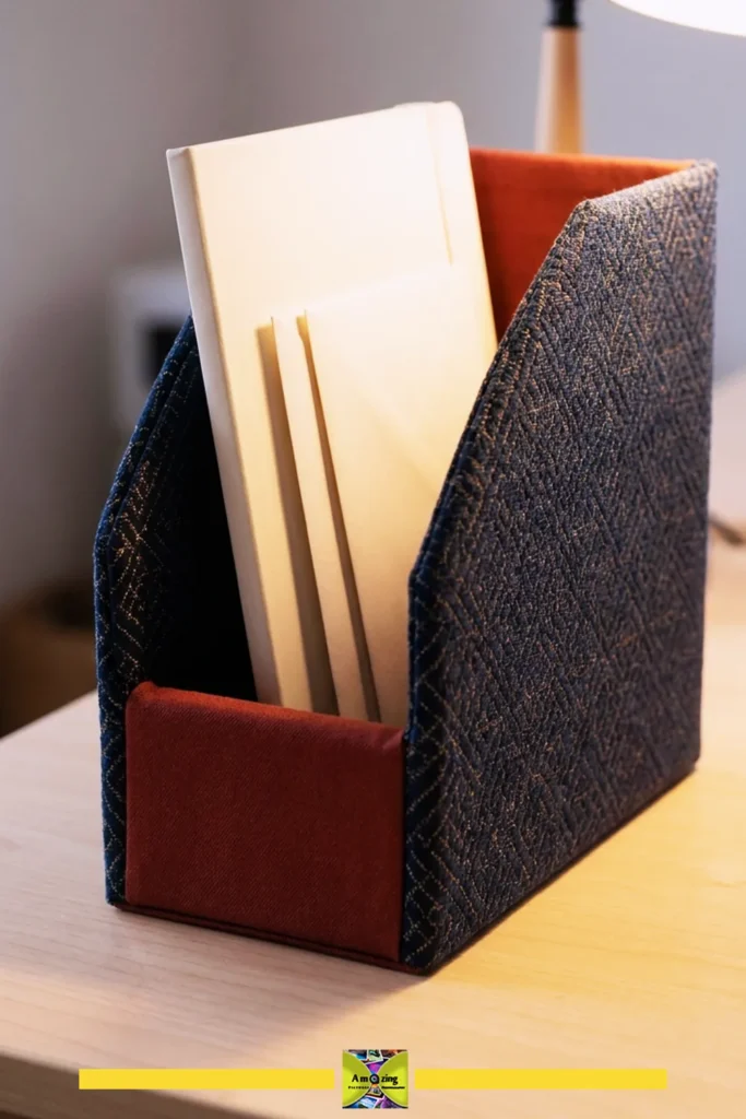 A fabric desktop organizer holding envelopes and a notebook on a wooden desk under warm lighting.