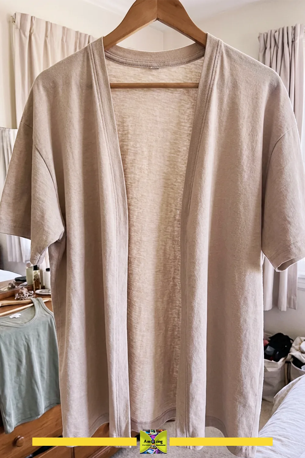 Beige open-front cardigan created from a repurposed t-shirt hanging on a wooden hanger