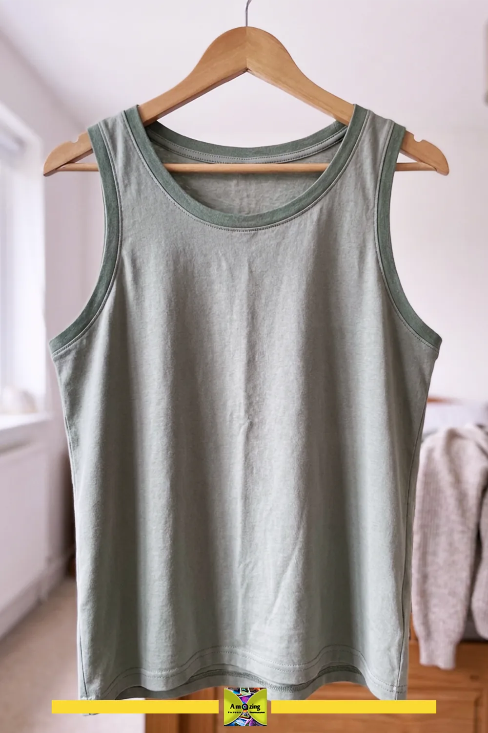 Handmade tank top with bound edges hanging on a wooden hanger in a bedroom setting.