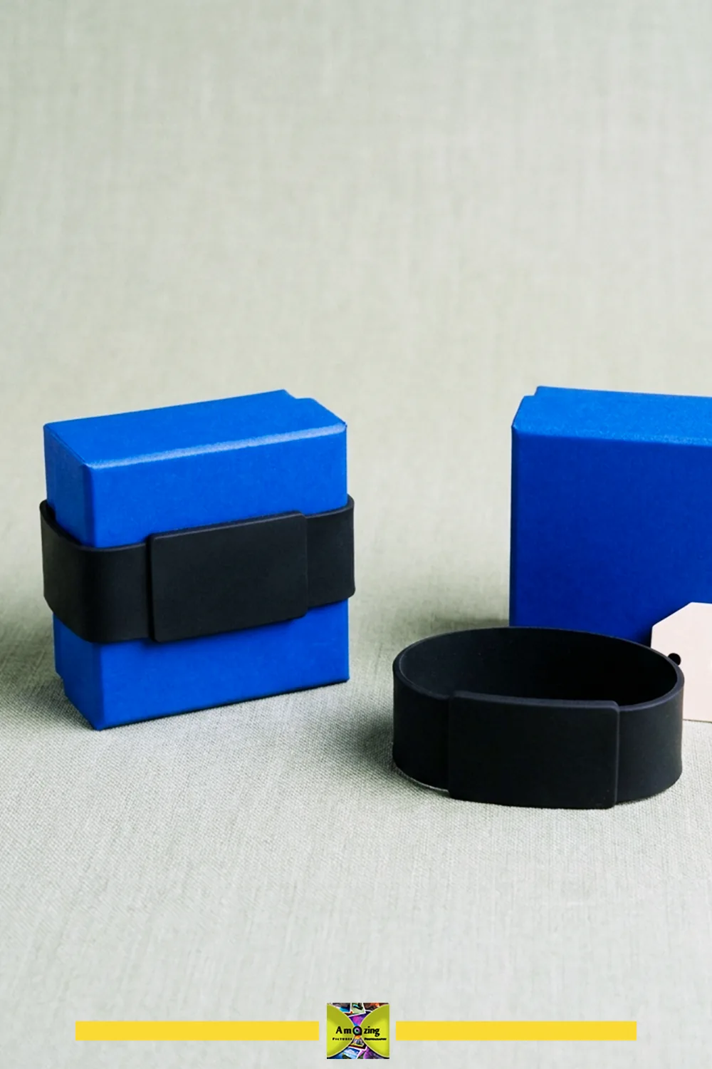 Black rubber gift-box band on a gift box and shown removed beside it