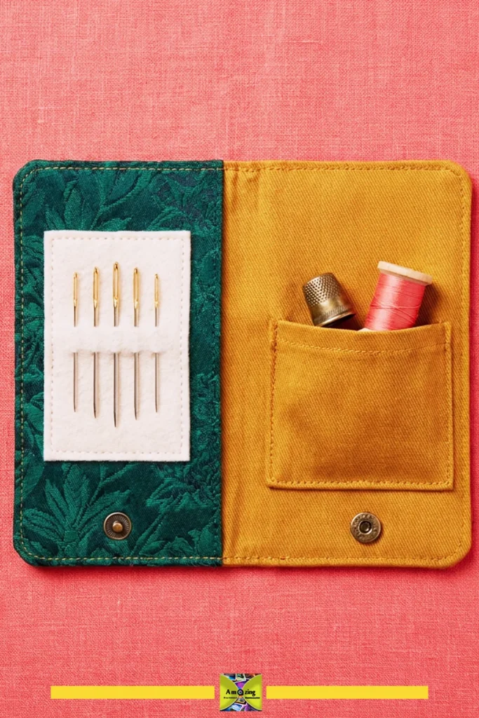 Open fabric needle book with needles, thimble, and thread on a pink background