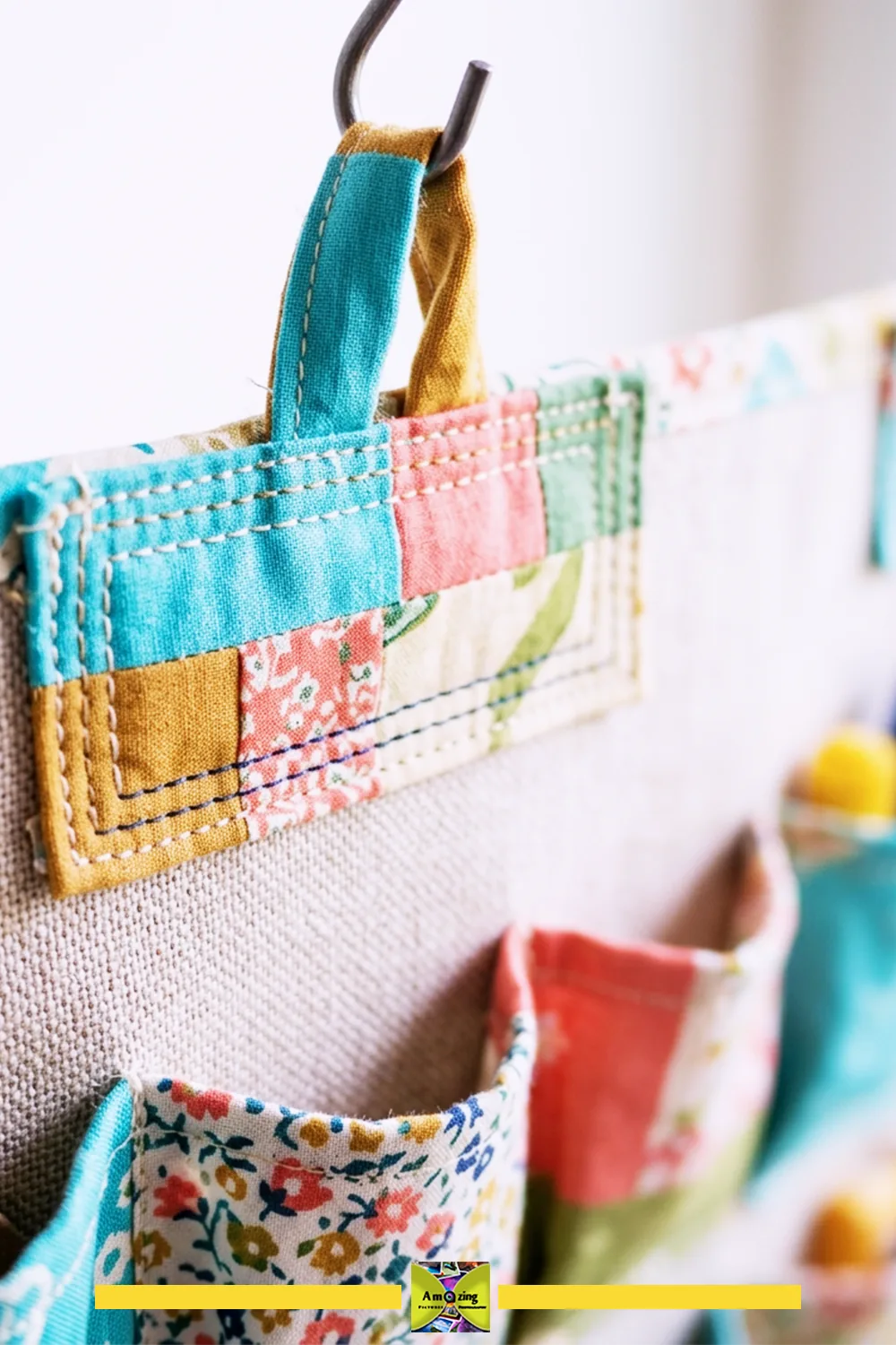 Close-up of a colorful fabric loop and hook mounting point on a hanging craft organizer.