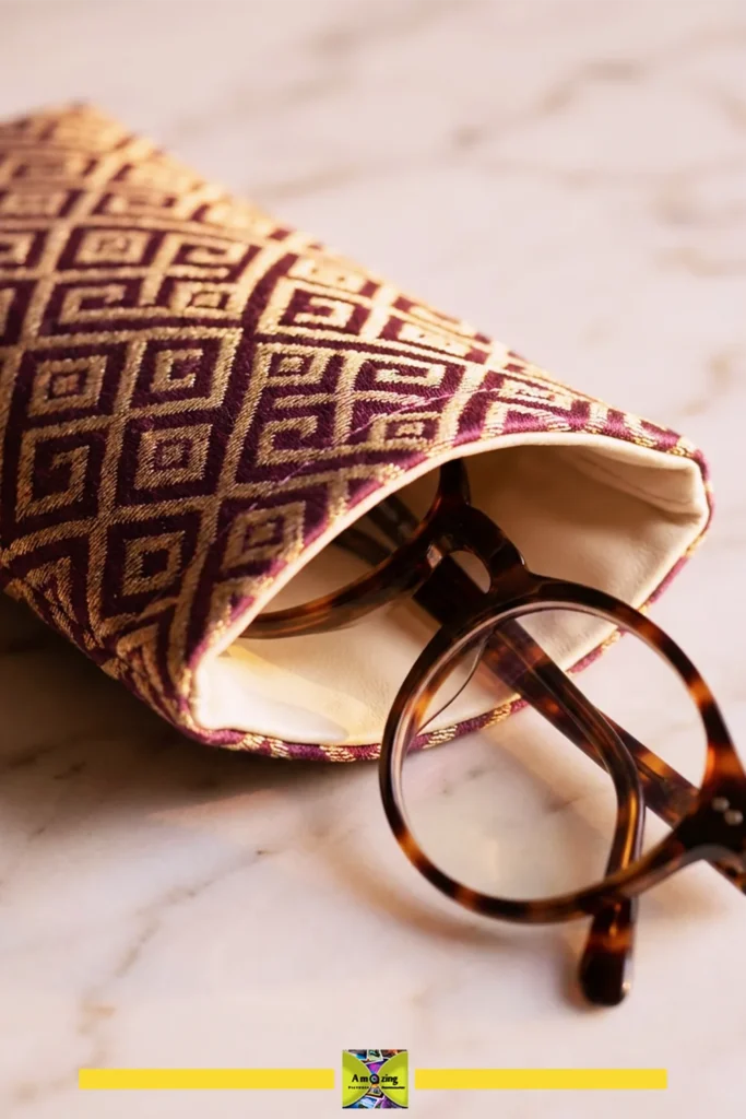 Patterned fabric eyeglass case with reinforced opening and round tortoiseshell glasses on marble surface