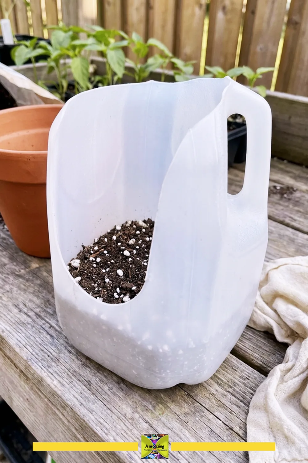 A homemade scoop made from a repurposed plastic jug filled with potting mix on a wooden table.