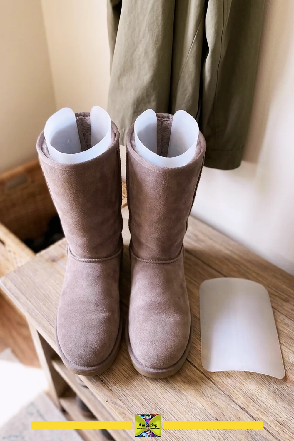 Pair of tall suede boots with white removable boot-shaft shaping inserts on a wooden surface.