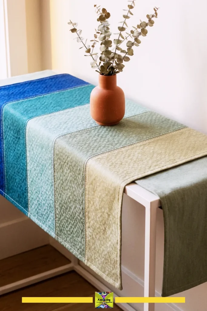 Console table with a reversible, color-blocked runner in blue and green shades and a terracotta vase with eucalyptus