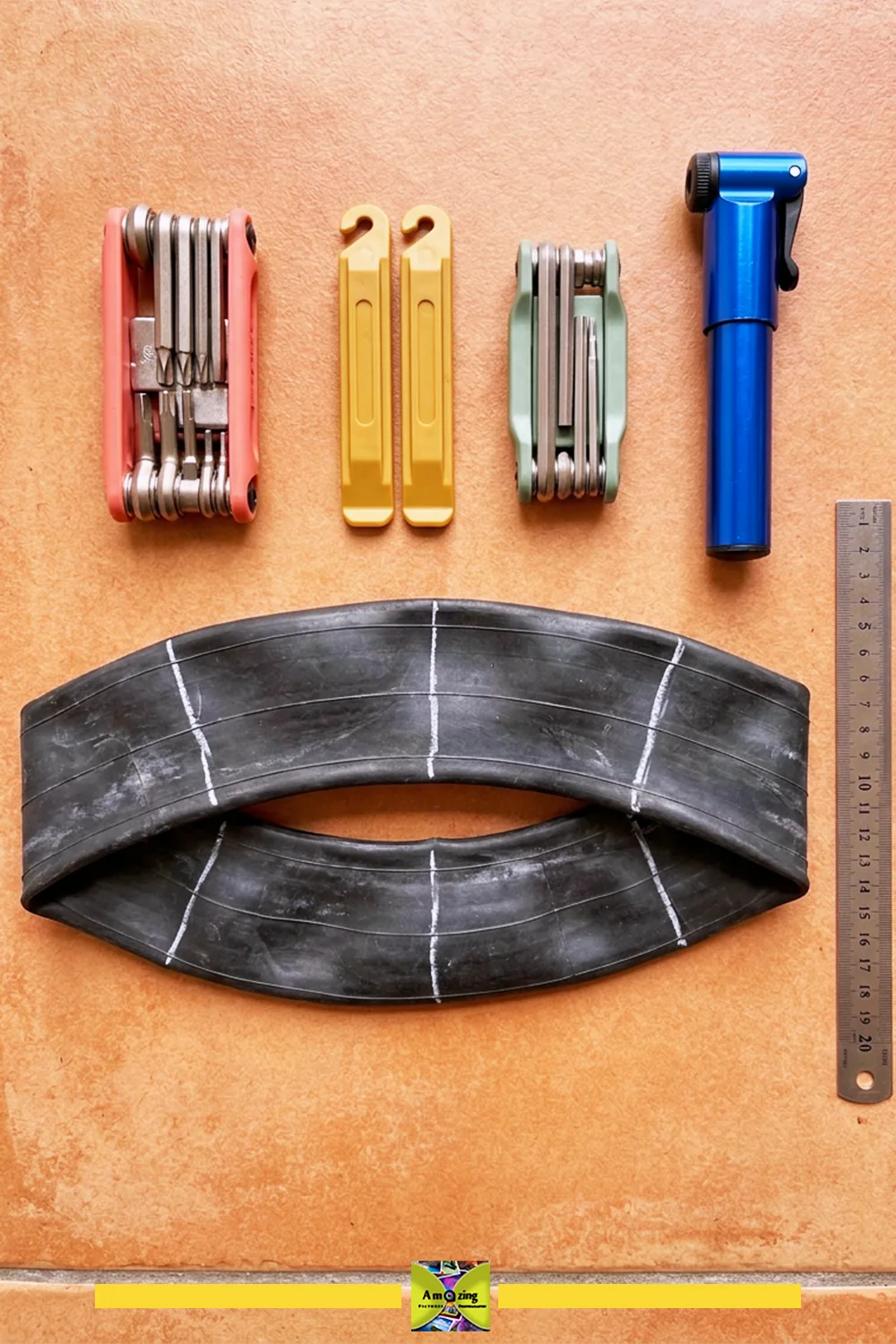 Lightweight hand tools laid out beside a marked black inner tube before cutting the tool roll