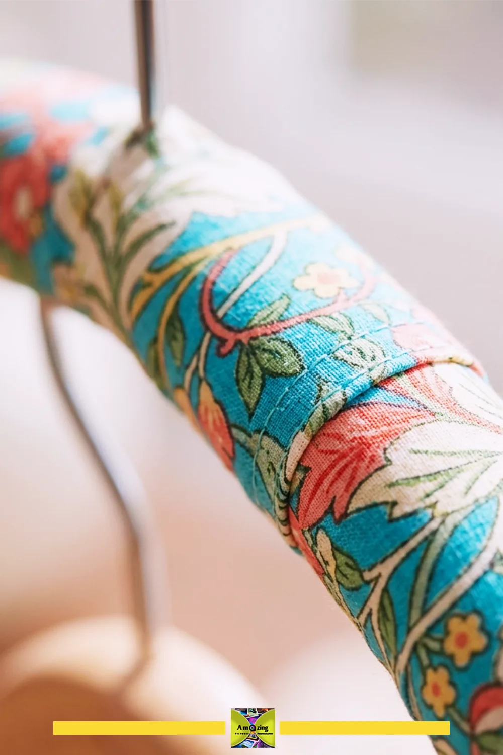 Close-up of a hanger wrapped in colorful floral fabric showing shoulder detail.