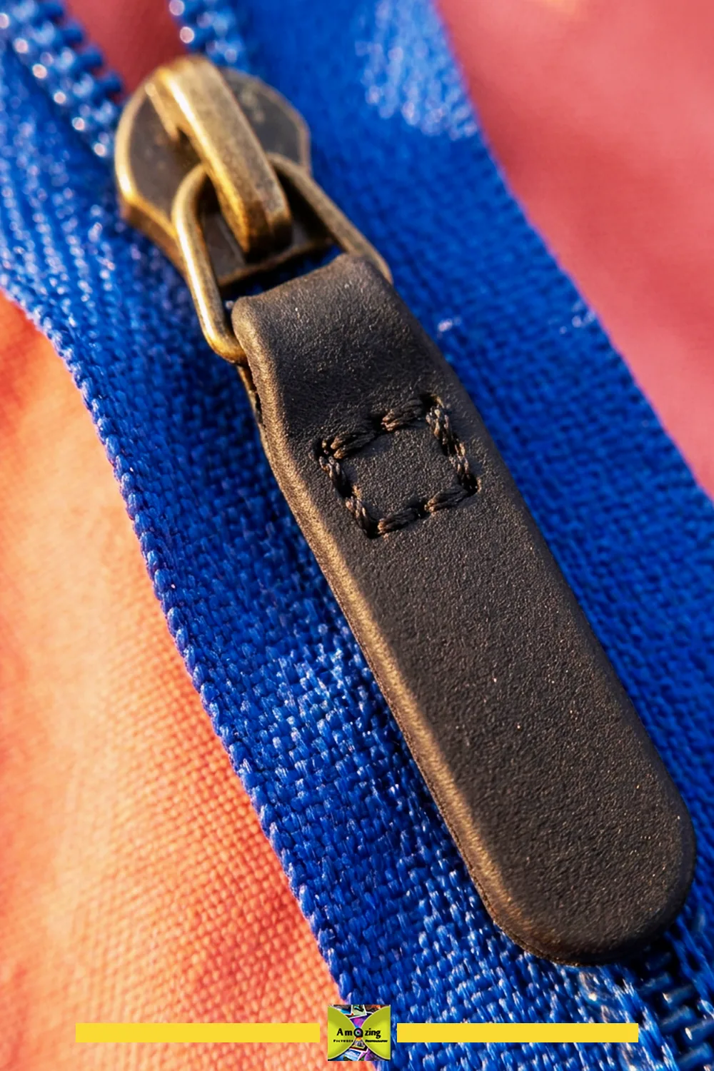 Black rubber zipper pull tab on a zipper showing the reinforced attachment