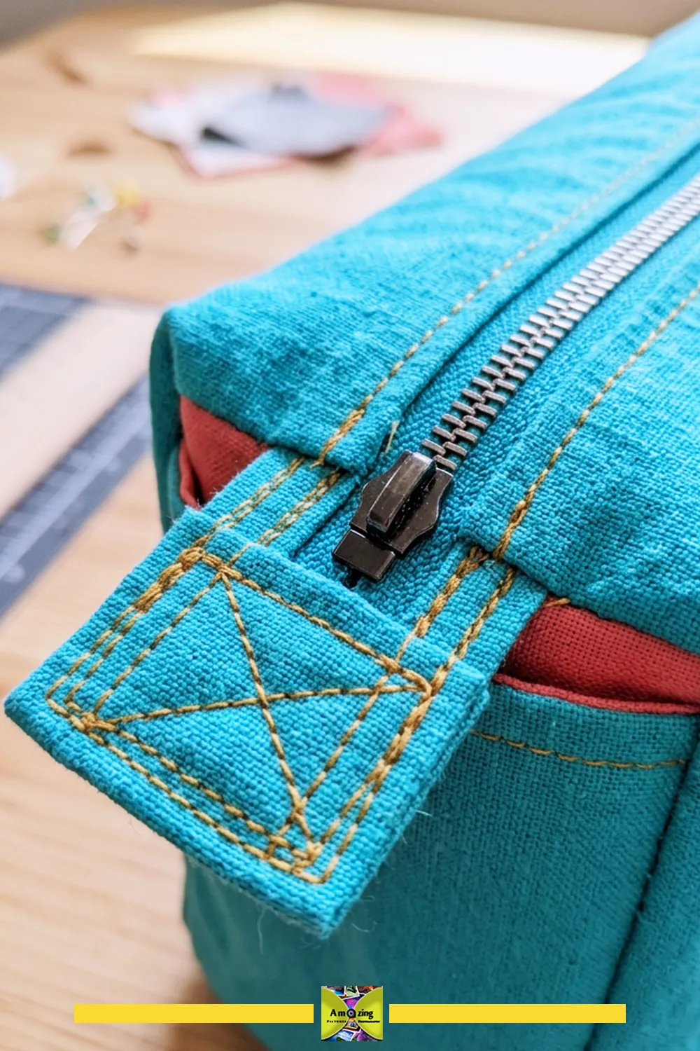 Close-up of a blue fabric storage case with a metal zipper and reinforced stitched end tab