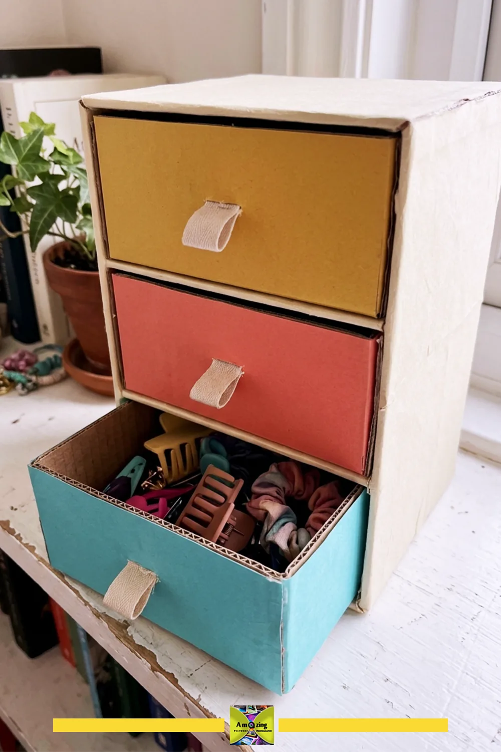 DIY cardboard mini drawers with colorful fronts and fabric pull tabs, holding hair clips and scrunchies