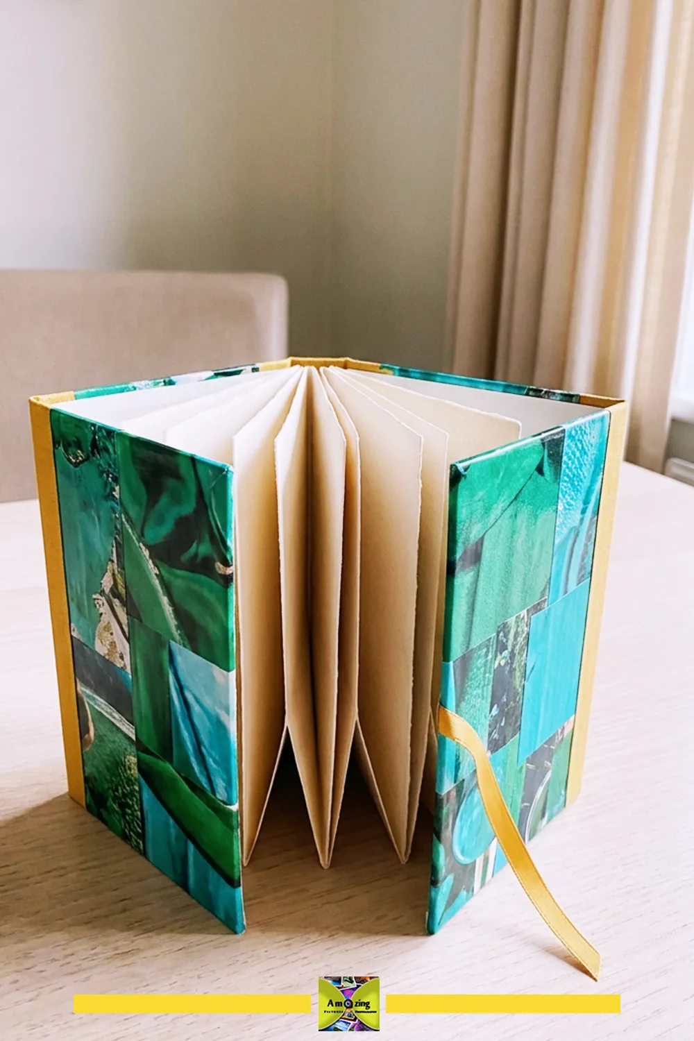 Handmade accordion-style letter folio with colorful magazine page covers and yellow ribbon on a table.