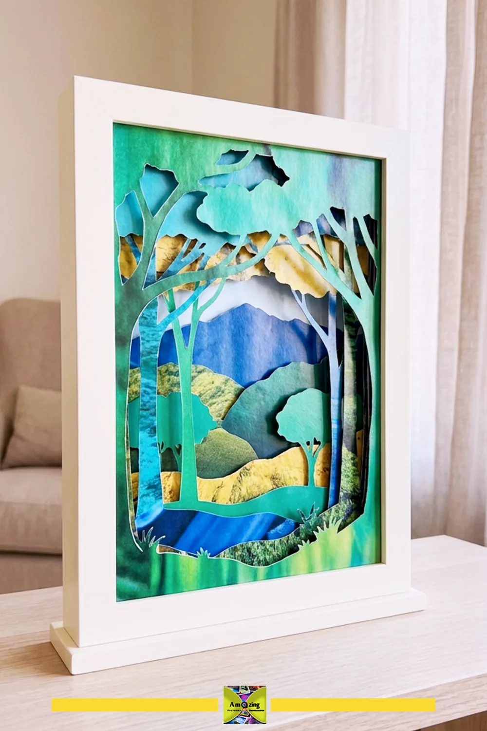 Framed layered paper art scene made from colorful magazine cutouts depicting trees and a landscape.