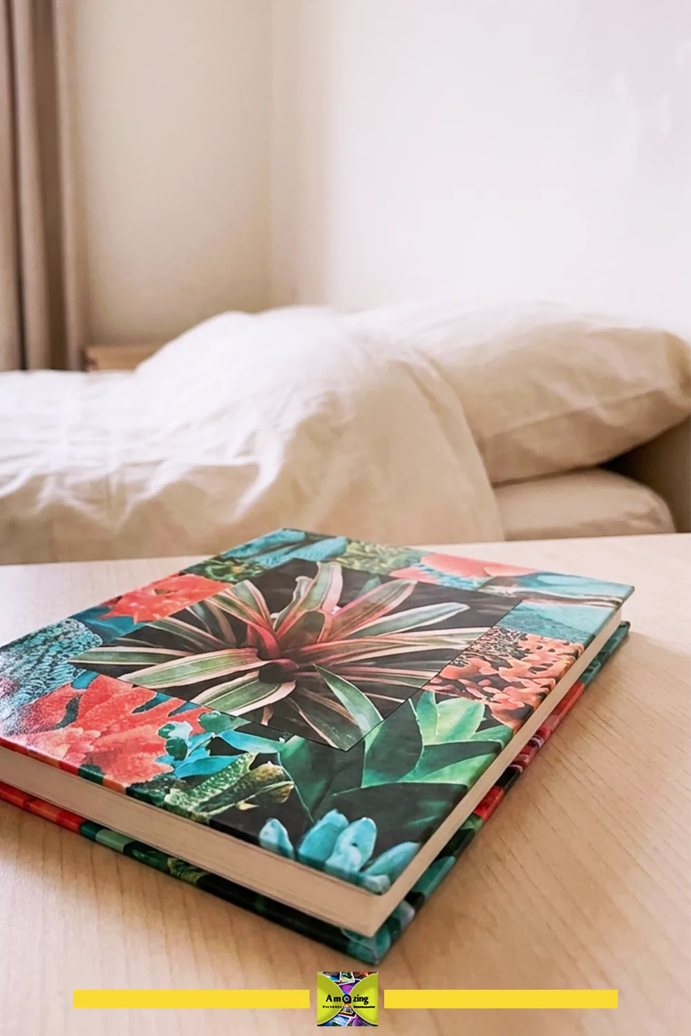 Handmade notebook with a vibrant magazine collage cover on a wooden table in a cozy bedroom.