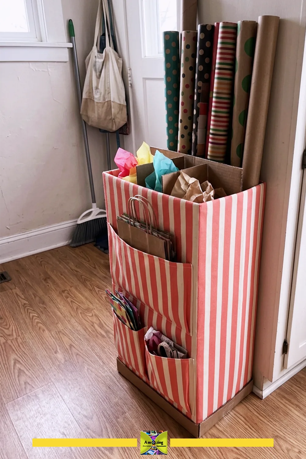 DIY gift-wrap organizer from a tall cardboard box covered in striped fabric, holding wrapping paper rolls