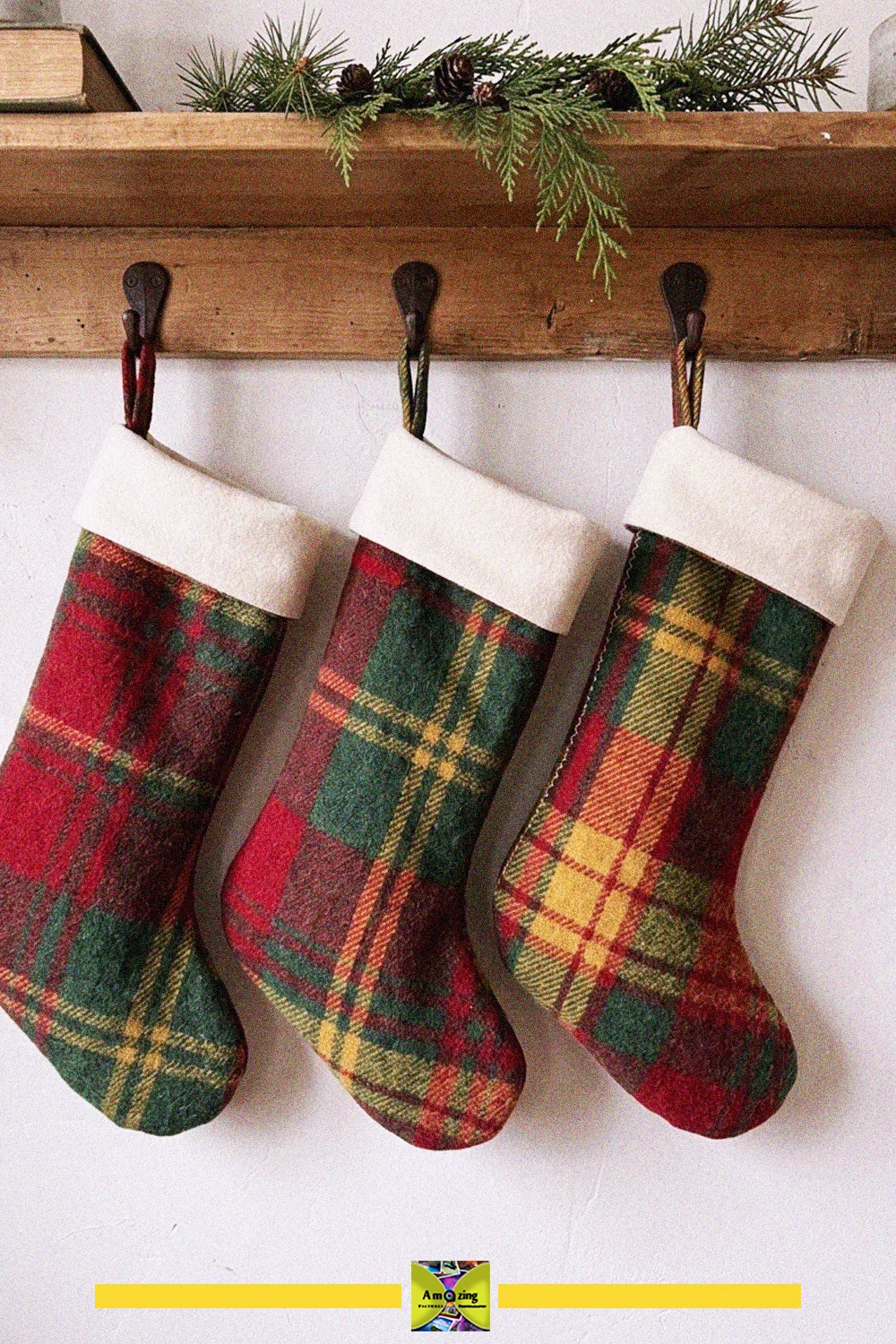 Three red, green and gold plaid holiday stockings with white cuffs made from an old blanket, hung on hooks