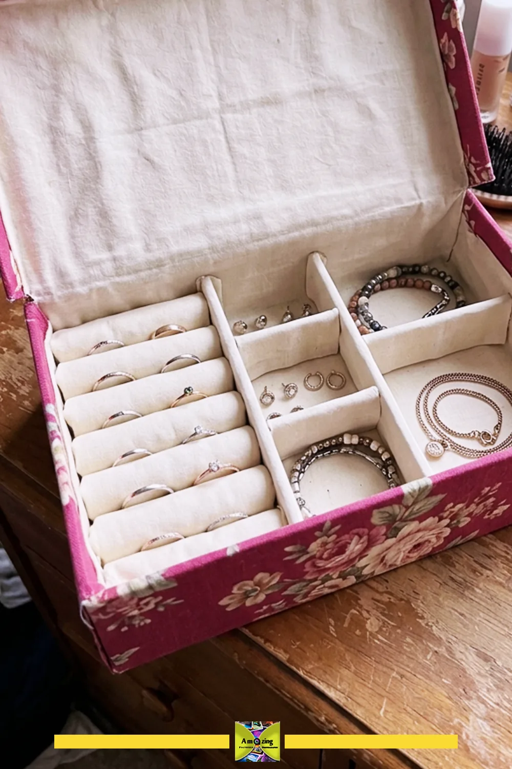 Open shoebox jewelry organizer with compartments holding rings, bracelets and earrings