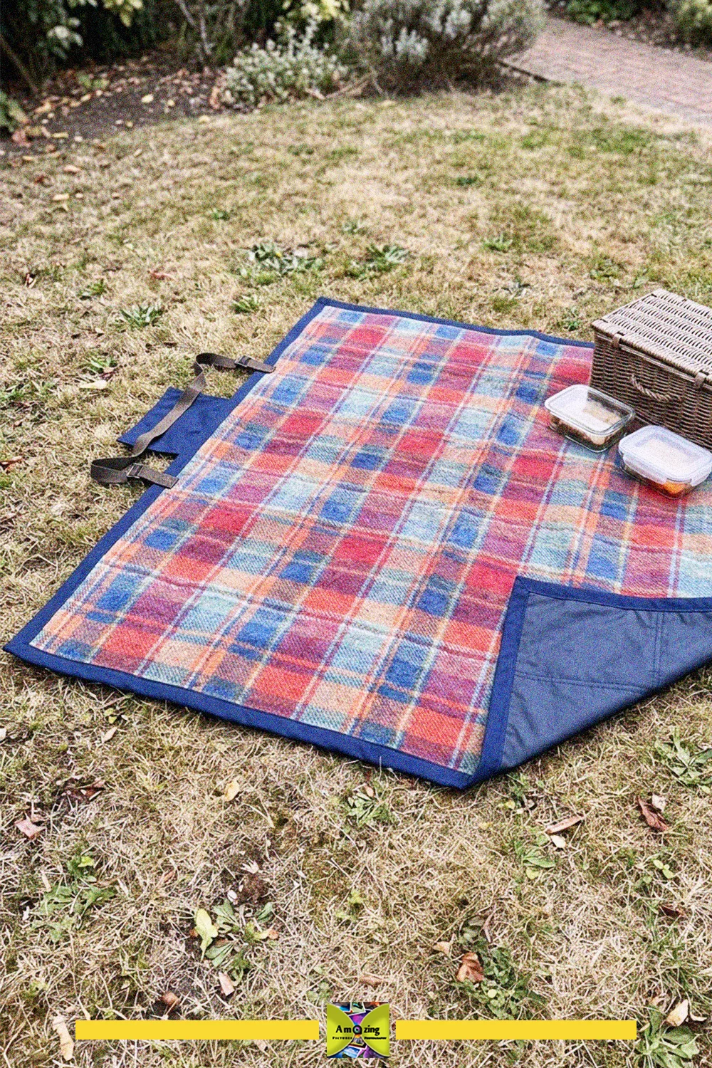 What to do with old blankets: a plaid picnic blanket with a waterproof blue backing on the grass